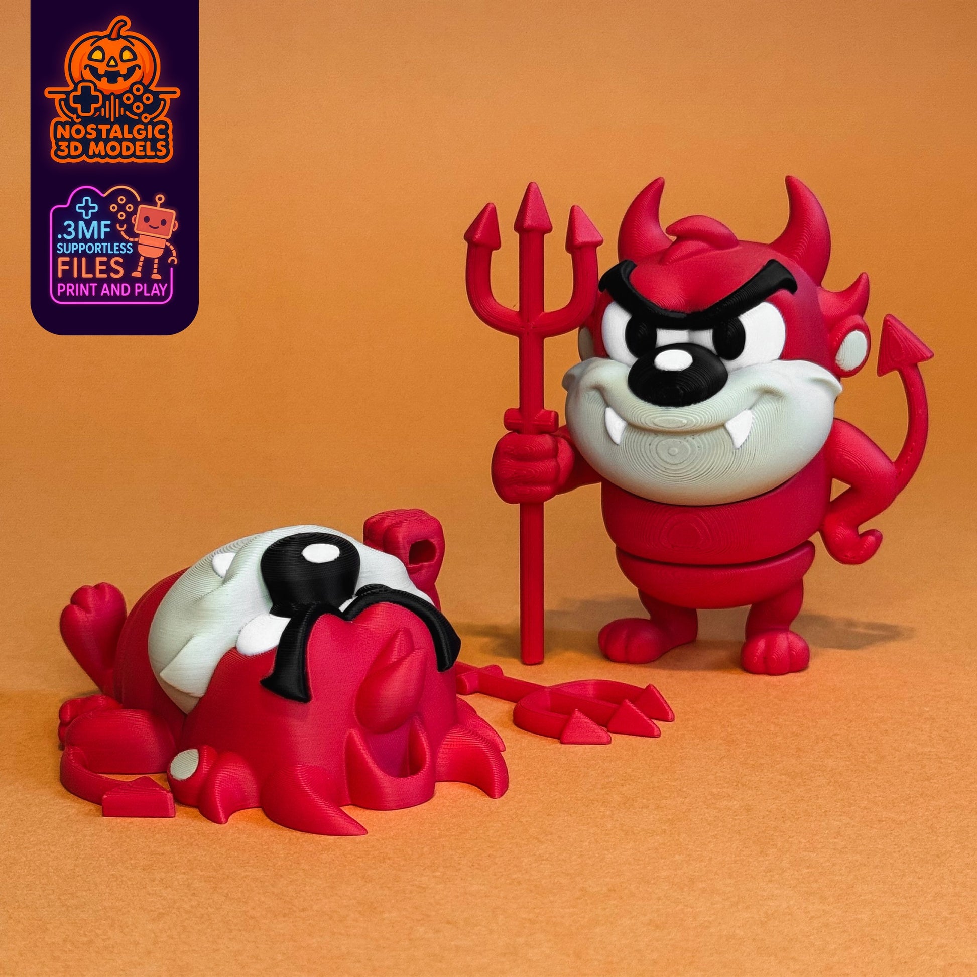 Two 3D printed Tasmanian Devil figures in Halloween devil costumes. One figure is standing upright, holding a red trident with a mischievous grin, while the other is lying dramatically face-down. Both have red bodies, white faces, horns, tails, and fangs. Background is a warm orange backdrop.
