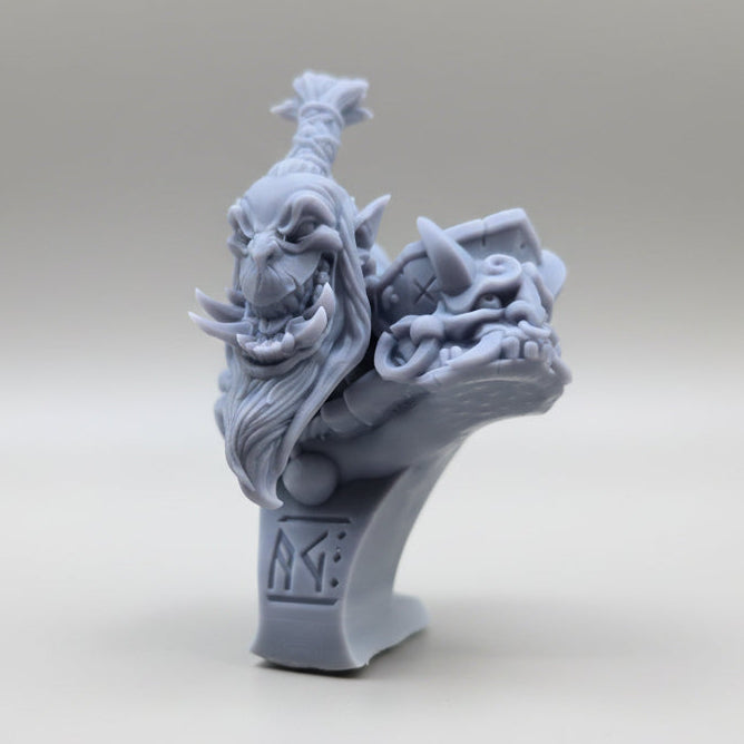 Side angle of a grey resin Oni bust showing intricate hair, tusks, and shoulder details, sculpted by Artisan Guild.