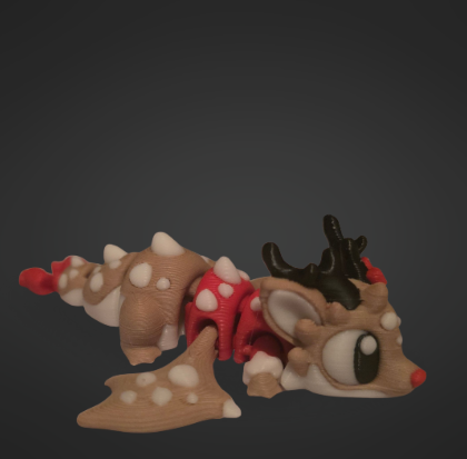 A 3D printed flexi dragon designed like a gingerbread reindeer, with brown and white icing details, tiny red accents, and black antlers. The dragon is posed lying down on a dark background, showing off its festive colouring and flexible design.