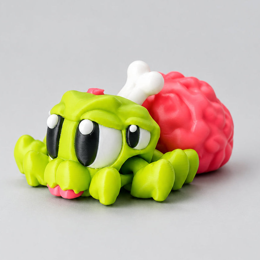 Cute 3D-printed Halloween zombie spider with a bright green articulated body, large black-and-white eyes and a pink exposed brain with a white bone sticking out.