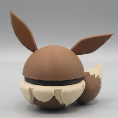 Back view of Eevee inspired Pokéball 3D print showing large pointed ears, brown body, fluffy cream fur details, and cute display style.