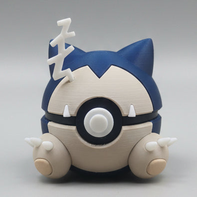 3D printed Snorlax inspired Pokéball collectible featuring Snorlax’s blue and cream colours, pointed ears, sleepy face details, small feet and a white sleepy symbol on top. A cute Pokémon themed display piece photographed on a grey background.