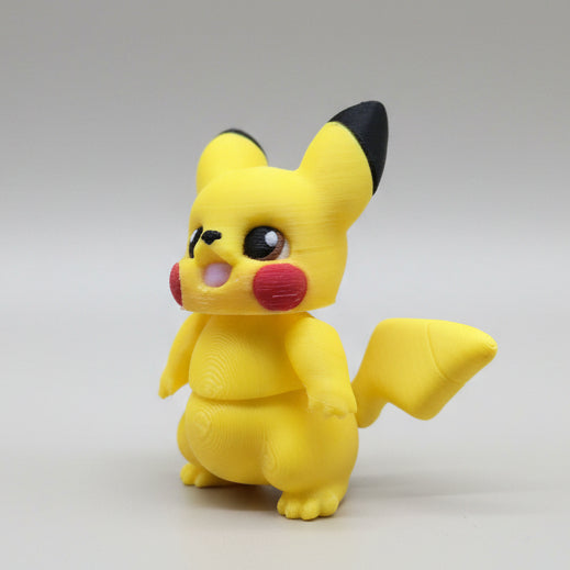 Three-quarter view of Pikachu flexi toy showing lightning bolt tail shape, black ear tips, and glossy eyes