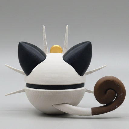 Cat-shaped Meowth pokeball with black ears, brown tail, and gold top on a gray background