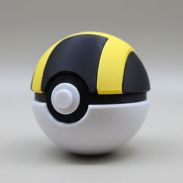 Angled view of a 3D printed Ultra Ball featuring a black and yellow top, white bottom half, and detailed centre button on a neutral backdrop.
