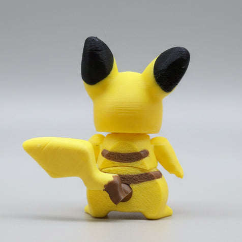 Rear view of Pikachu 3D printed figure displaying lightning bolt tail detail and brown back stripes