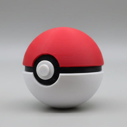 Angled side view of a 3D printed Pokéball showing the red dome, black band detail, and circular white button.