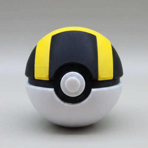 3D printed Ultra Ball with black top and bold yellow stripes, white base and central button, shown against a plain light background.