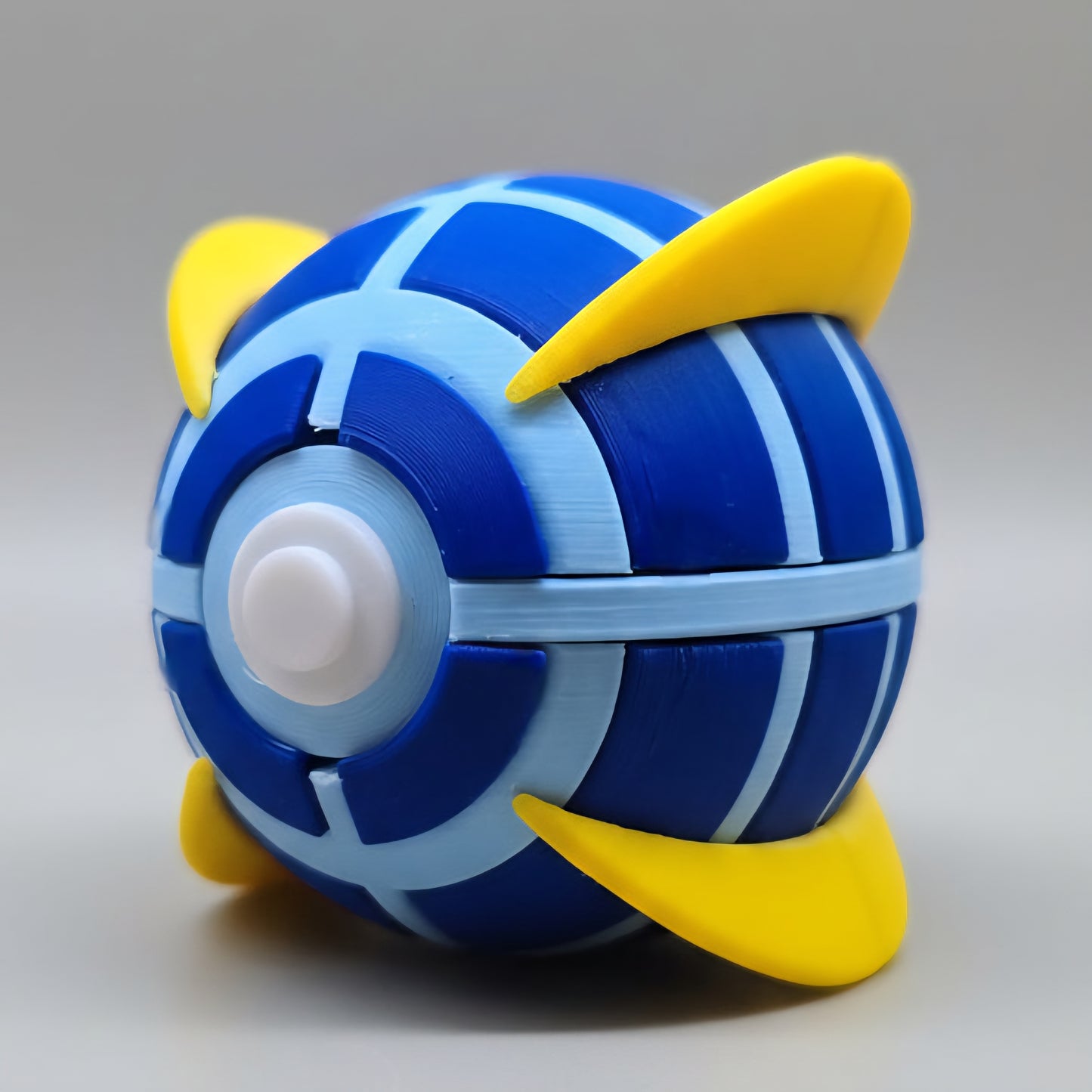 3D printed Beast Ball in deep blue with light blue panel detailing and four yellow fin-like spikes, shown at an angle on a plain white background.