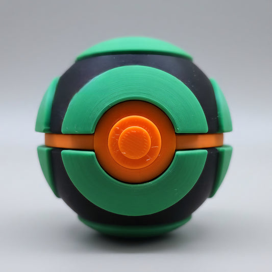 Front view of a 3D printed Dusk Ball featuring green curved panels over a black shell with a bright orange centre button and a white lower half, displayed against a neutral background.