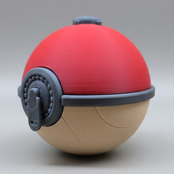 Angled view of a 3D printed Hisuian Poké Ball showing the red upper half, tan lower half with carved texture lines, and raised grey clasp mechanism on the front.
