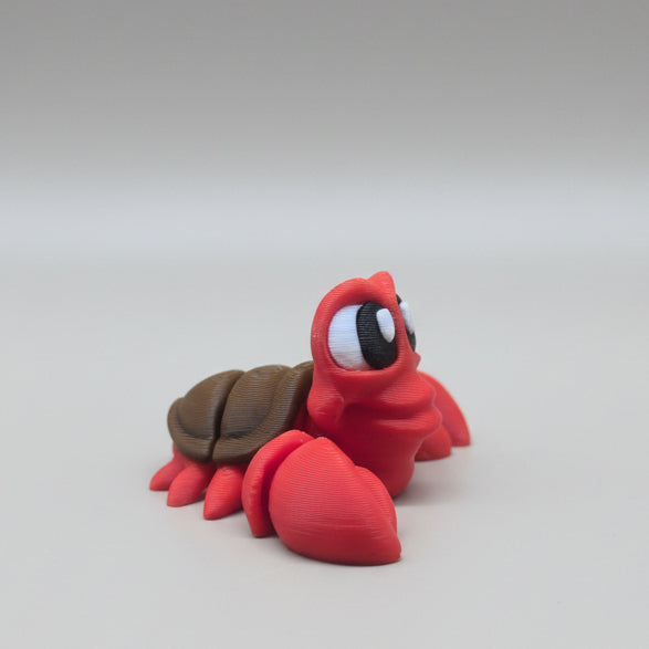 Side view of a red Sebastian flexi crab figure showing articulated body and shell