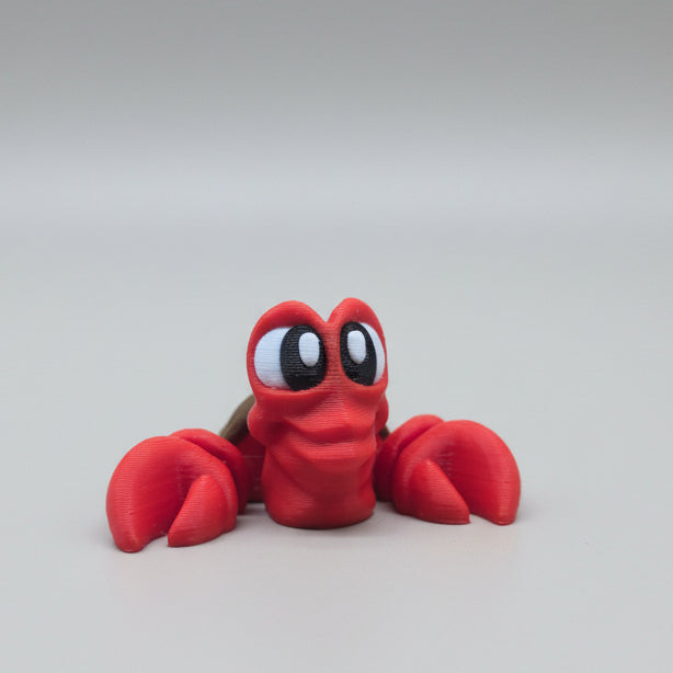 Red 3D printed Sebastian crab flexi figure facing forward on a light background