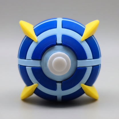 Front view of a 3D printed Beast Ball featuring dark blue and light blue segmented panels, white centre button, and four yellow spike accents on a clean white background.