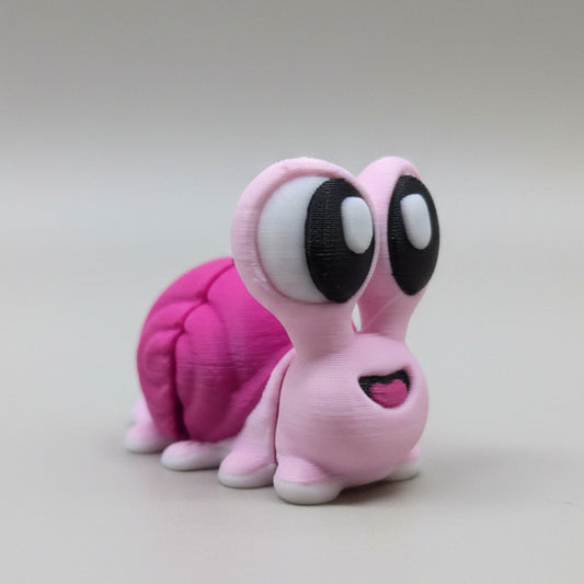 Pink toy with large black eyes on a light gray background